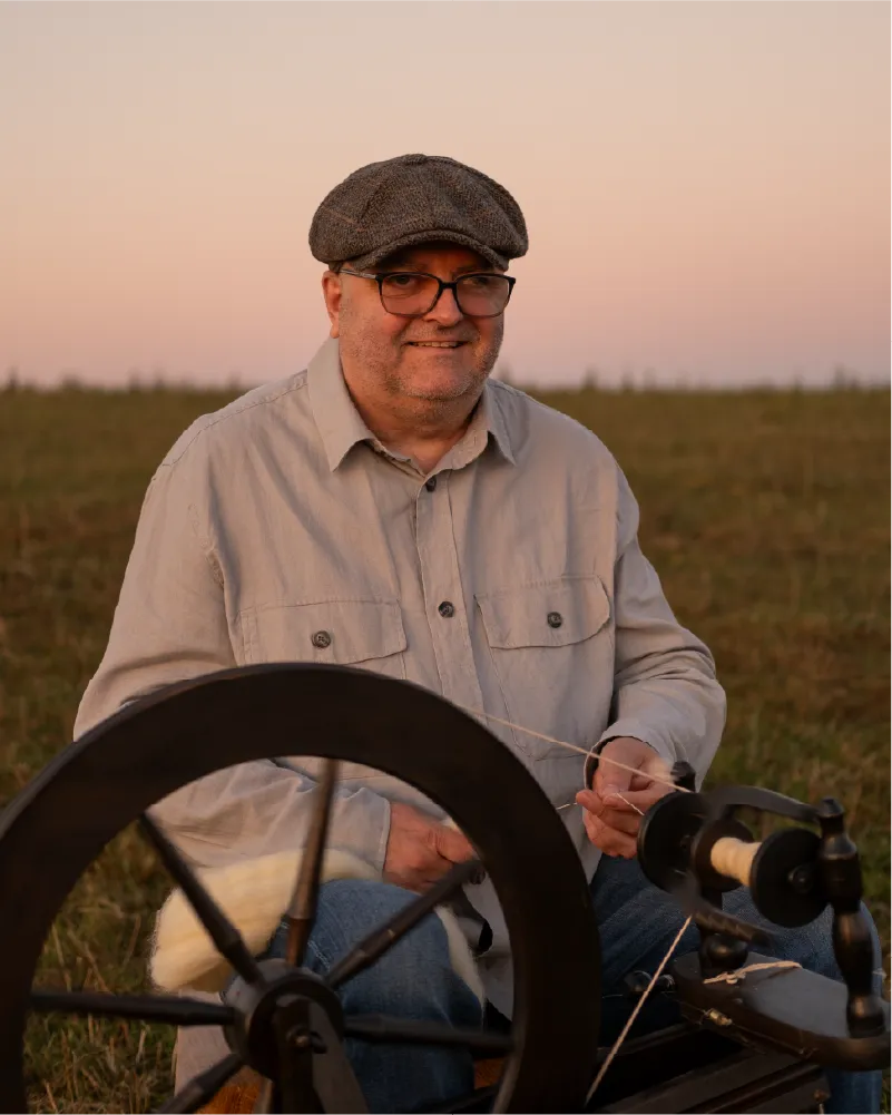 Peter spinning yarn by hand at his spinning wheel
